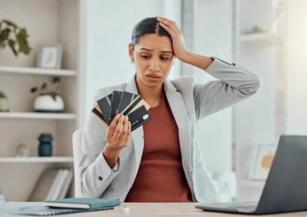 Financial stress concerned and frustrated woman holding bank cards