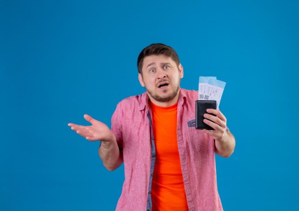 man holding airplane tickets clueless and confused