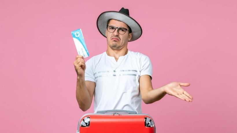 young man holding plane ticket