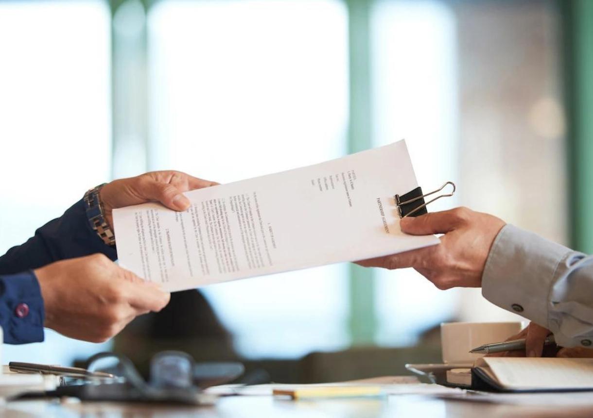 Closeup of hands passing the contract