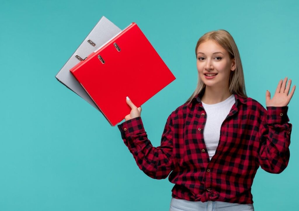 girl in red checked shirt smiling with file folders