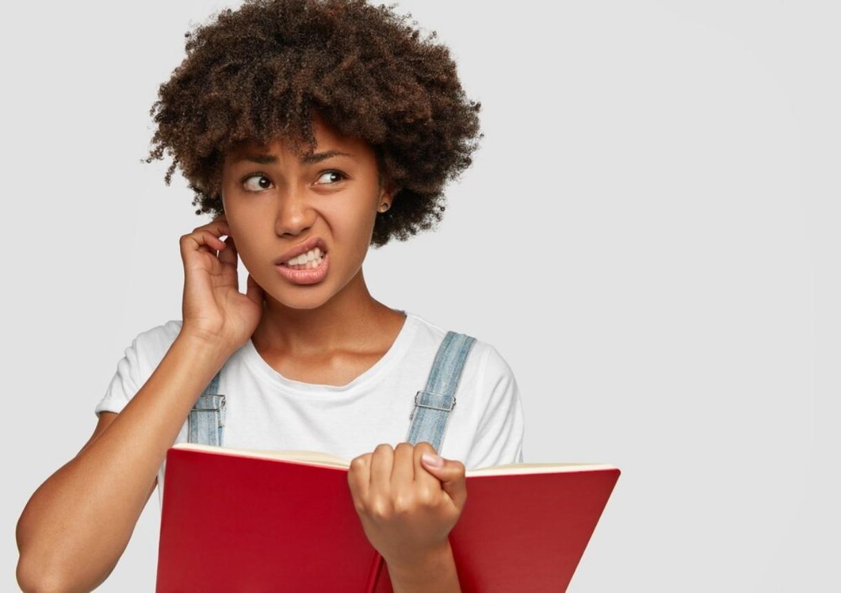 girl with study book confused