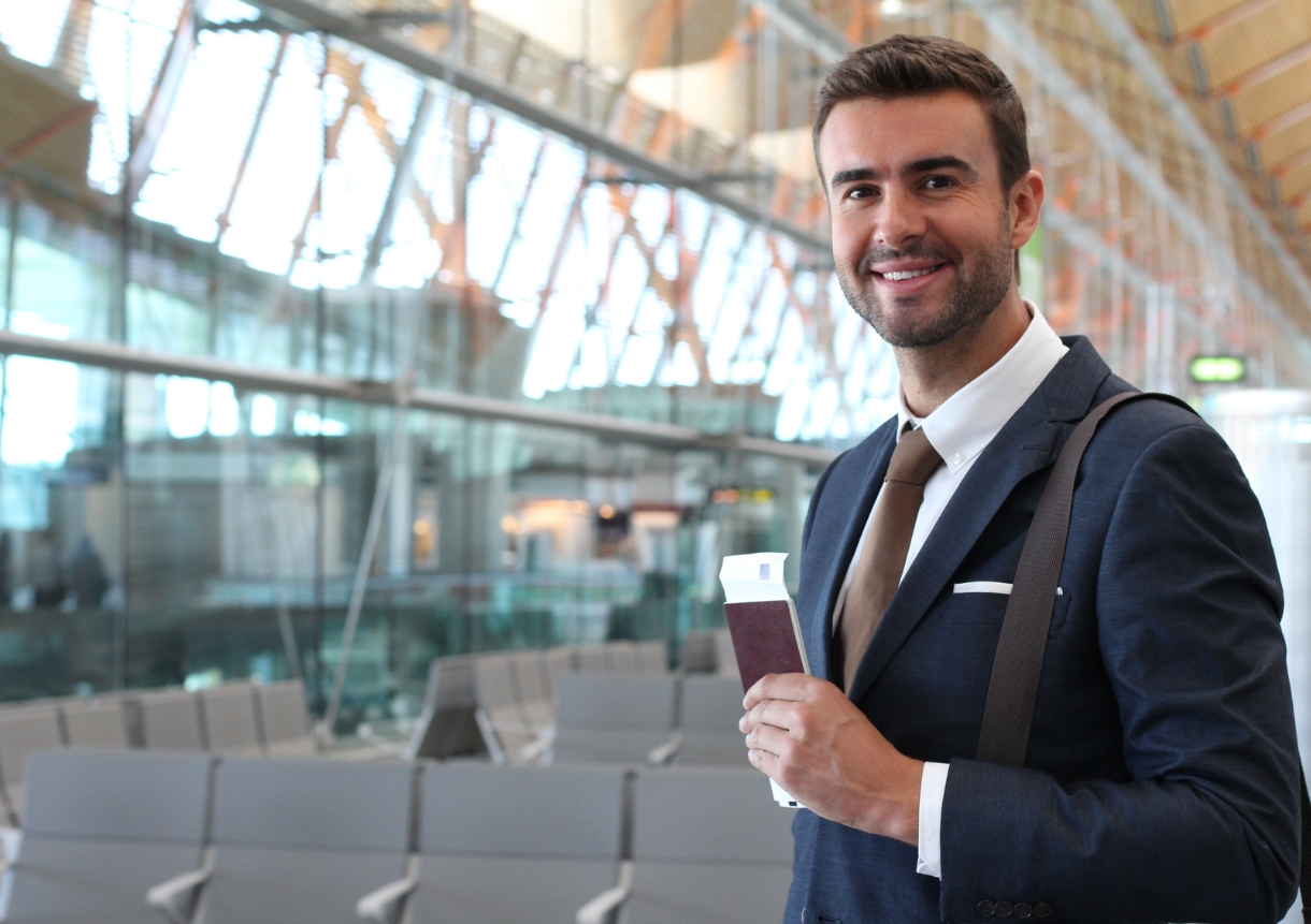 Handsome businessman smiling at the airport with uk business visa