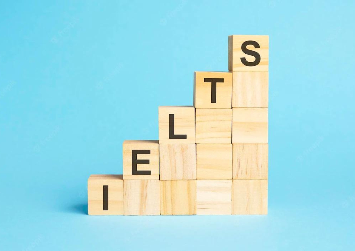 The word ielts is written on a wooden cubes concept with blue background