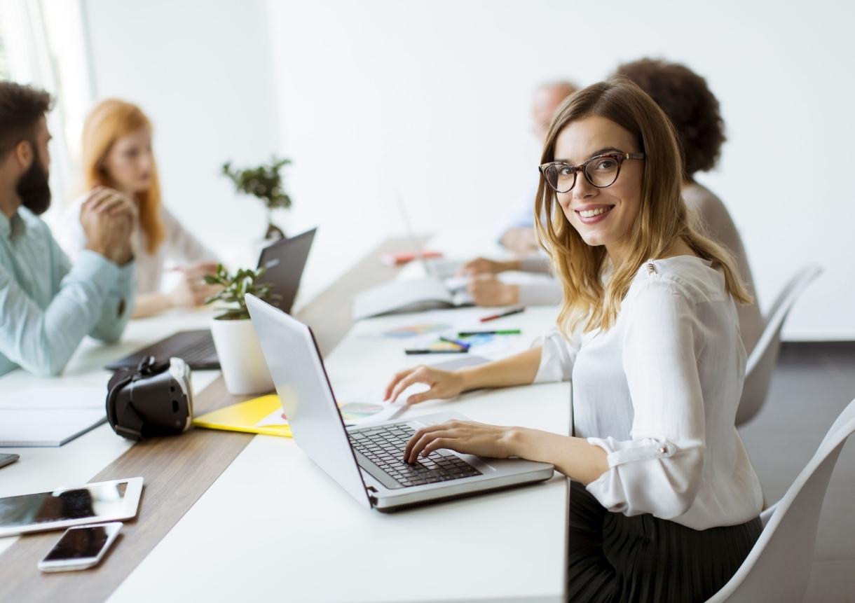 happy women working on a laptop in an office